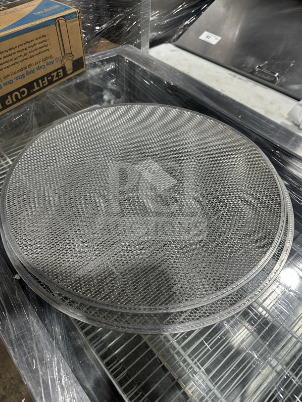 New commercial stainless steel pizza screen, mesh design, durable construction, pristine condition, bid includes two pieces.