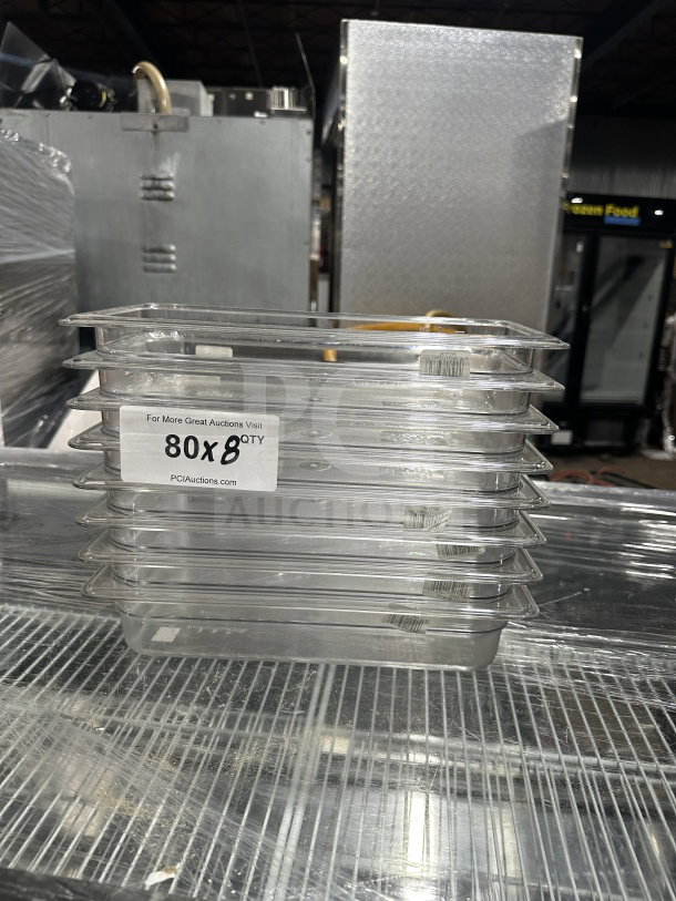 Stack of new Cambro commercial 1/3 size clear polycarbonate food pans, model 631-1, 2.5" deep, with "8X Your Bid" label.