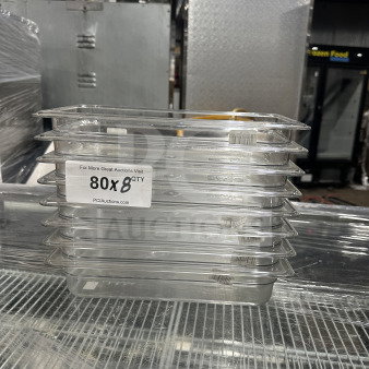 Stack of new Cambro commercial 1/3 size clear polycarbonate food pans, model 631-1, 2.5" deep, with "8X Your Bid" label.