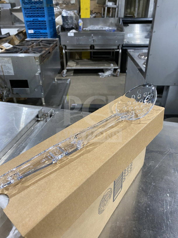 Brand new Cambro Camwear Series clear 13” perforated deli spoon, model SPOP13CW135, shown on cardboard box.