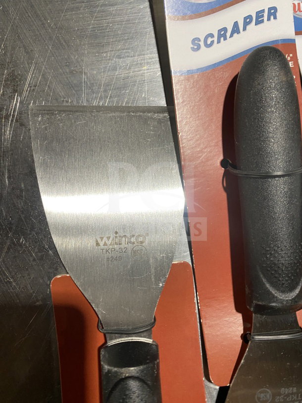 Winco TKP-40 handheld scraper, stainless steel blade, black slip-resistant grip, brand new condition.