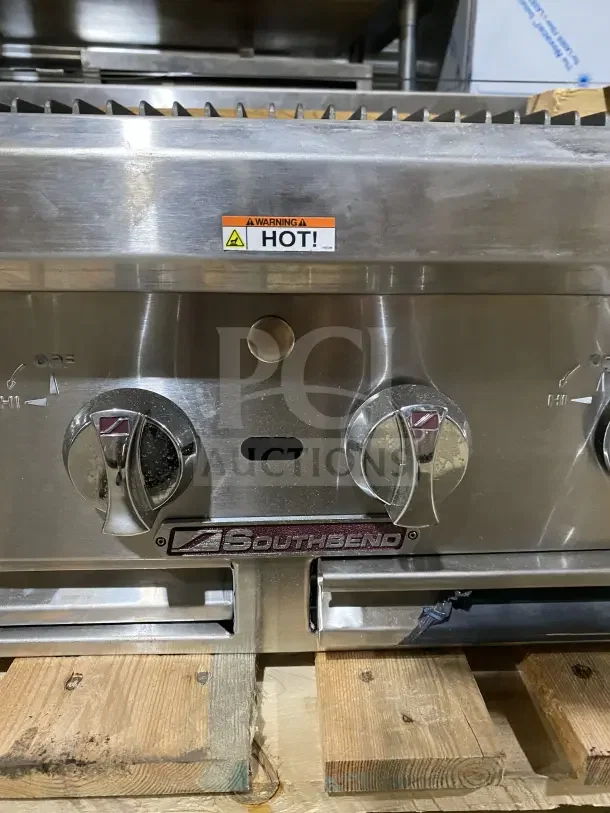 Brand new Southbend HDC36 stainless steel countertop gas char broiler grill with back and side splashes. Warning: Hot label.
