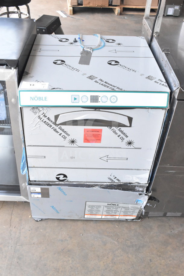 Brand new Noble 495LTUC24 low-temp undercounter dishwasher, 120V, 1 phase, visible scratches and dents, factory labeling intact.