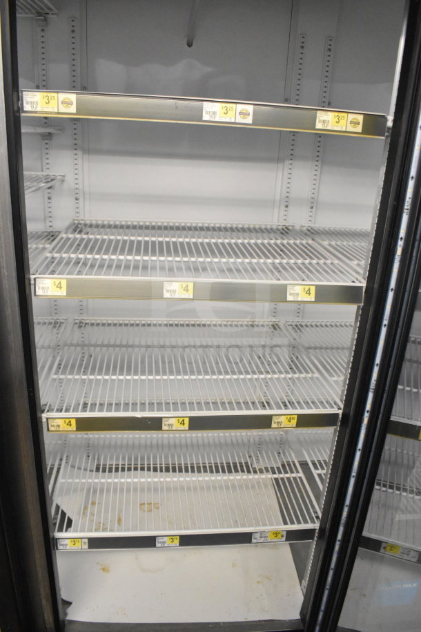 2016 True GDM-72-HC commercial cooler, 3 glass doors, metal shelving, 115V, 1-phase, with price labels on shelves.