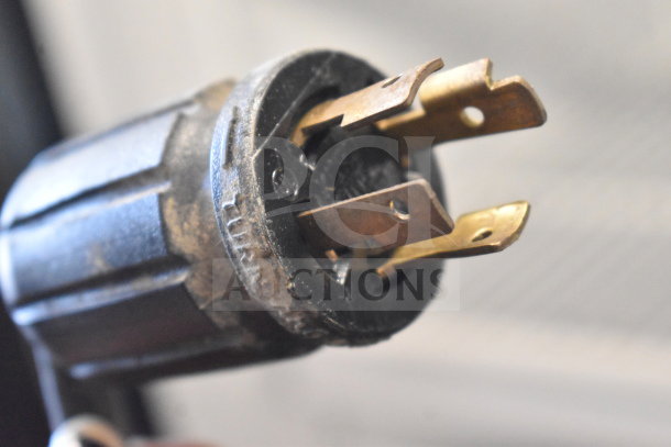 Close-up of a power plug from a 2016 True GDM-72F-HC Commercial Freezer, showing prongs and wear.