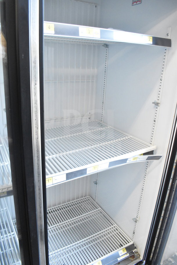 2016 True GDM-72F-HC commercial freezer, 3 glass doors, white interior, wire shelving, labels visible, good condition.