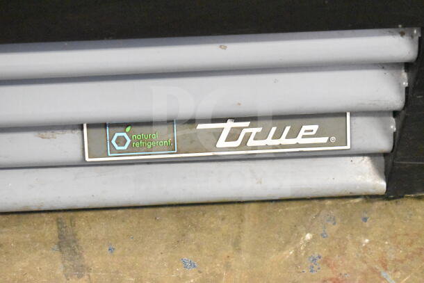 2018 True GDM-12-HC cooler. Features natural refrigerant label. Model tag shows brand and condition. Suitable for commercial use.