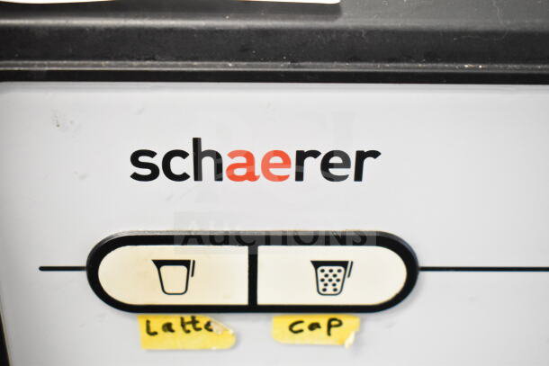 Schaerer Barista espresso machine control panel with dual buttons labeled for latte and cappuccino.