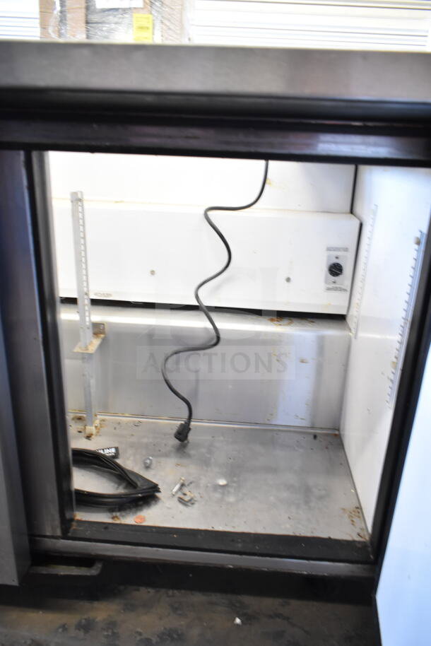 True TSSU-48-18M-B commercial prep table, missing lid, 115 volts, 1 phase, interior view, visible wiring and compartment.