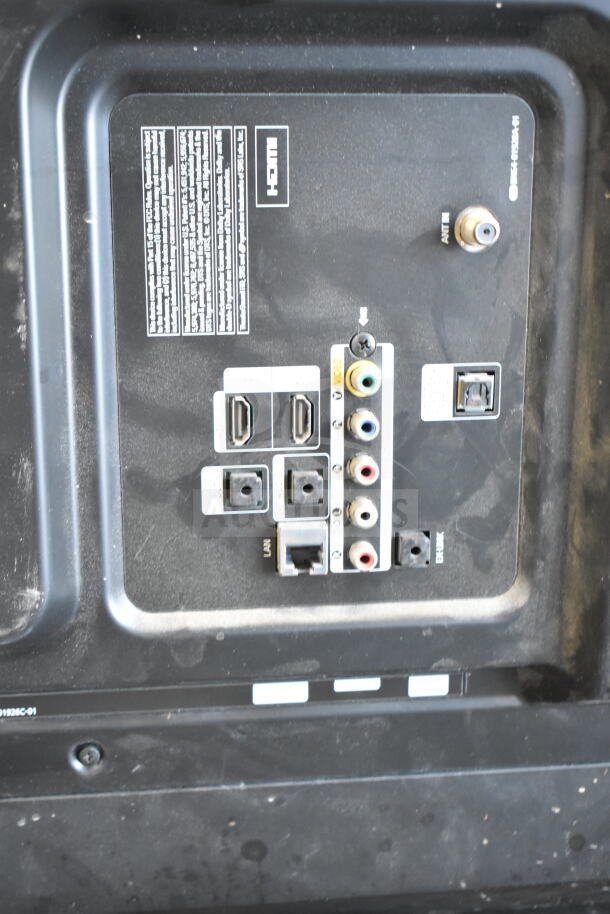 Back panel of television showing multiple input ports, including HDMI, LAN, and AV connections. Dust visible.