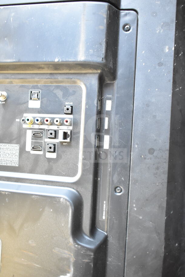 Back view of a television showing input ports and labels, indicating connectivity options. Visible wear on the plastic casing.