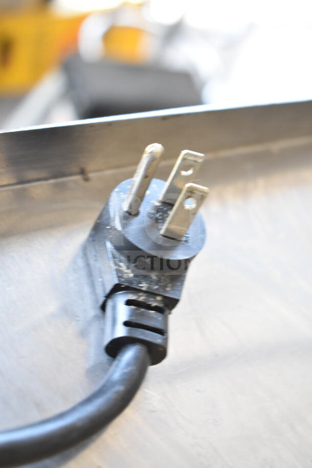 Power plug for a Delfield commercial sandwich salad prep table, showing a standard three-prong design.