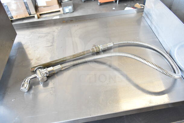 Metal hose assembly on a stainless steel surface, part of a lot including Moffat Element Assy and Avantco Gas Control Knob.