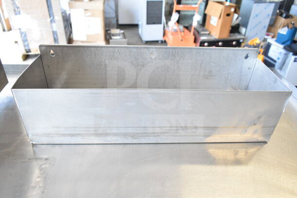 Metallic rectangular container, possibly part of a set of various items, showing minor wear. Includes two drilled holes for mounting.
