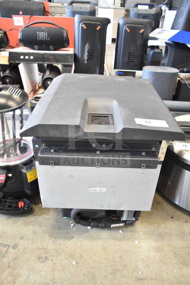 Auction item: Mini Cooler. Black top with metallic body, handles visible. Label indicates model number. Slight wear evident.