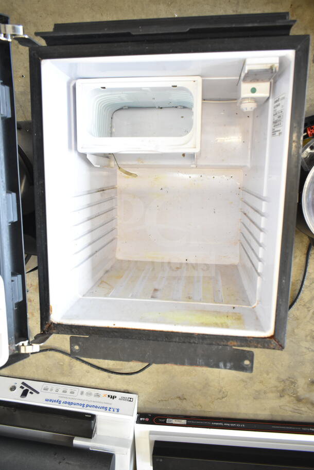 White mini cooler in used condition with visible signs of wear, including rust and dirt inside. Left open with empty interior.