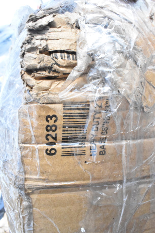 Damaged cardboard box wrapped in plastic, showing a barcode and visible text "HEAVY DUTY." Contains scratch and dent items.