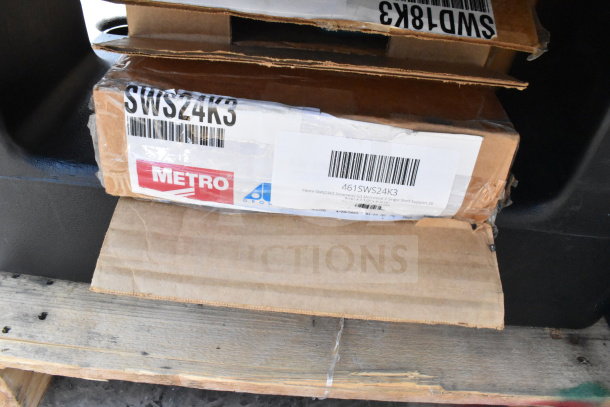 Boxes of Metro SWS24K3 brand new scratch and dent items on pallet, including black poly dunnage racks.