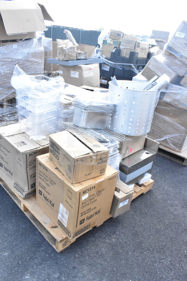 A pallet loaded with various new kitchen items, including tumblers, drainboards, lids, in scratch and dent condition.
