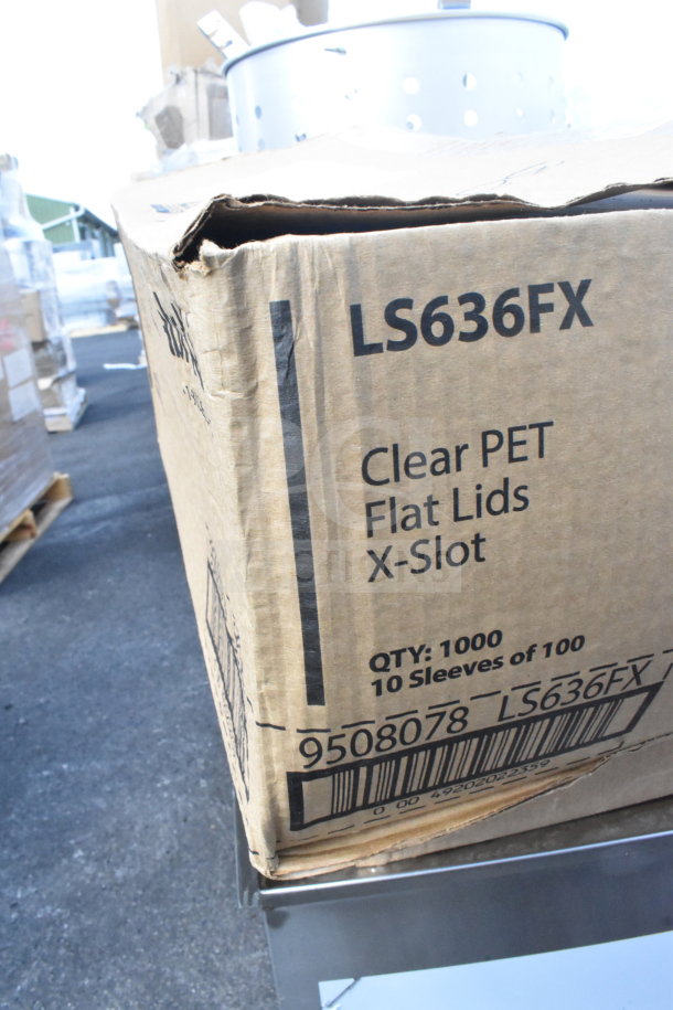 Cardboard box labeled "LS636FX Clear PET Flat Lids X-Slot." Contains 1000 units, 10 sleeves of 100. Minor wear visible.