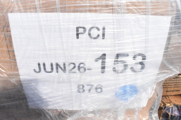 Clear plastic-wrapped pallet labeled "PCI JUN26-153," containing new scratch and dent items like coffee cups and containers.