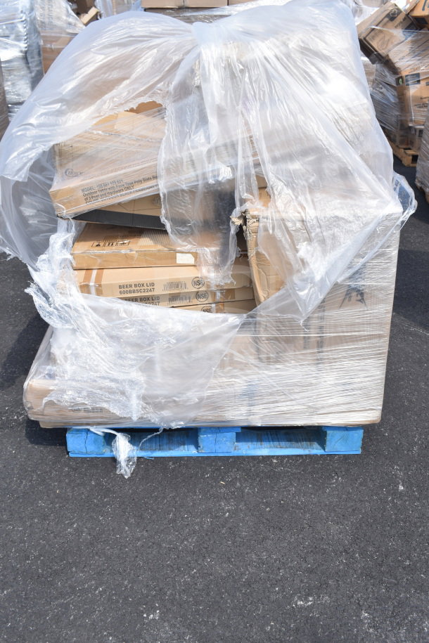 Shrink-wrapped pallet with brand new scratch and dent items including bus tub and beer box sliding lids, visible labels, on blue pallet.