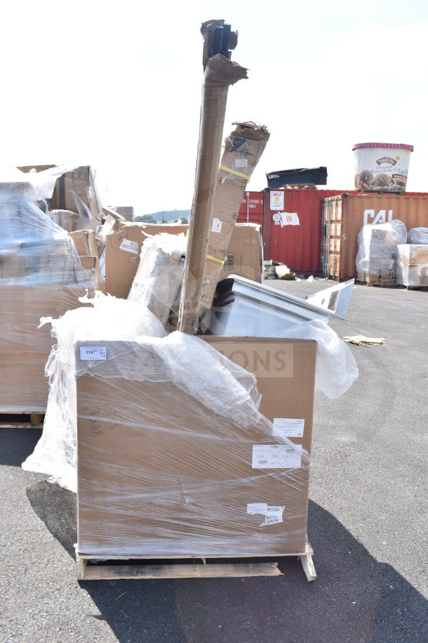 Brand new scratch and dent items on pallets, including a cart, tabletop, and sink. Wrapped in plastic with visible labels.