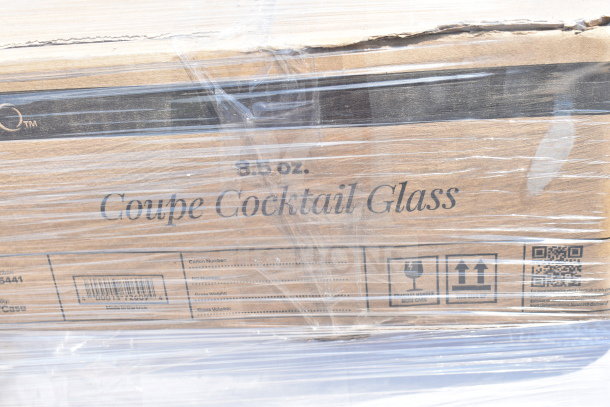 Box of 8.5 oz Coupe Cocktail Glasses, brand new with slight packaging imperfections, visible under clear plastic wrap.