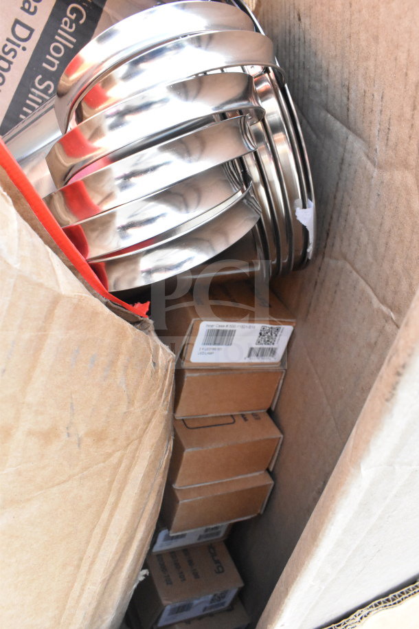 Cardboard box containing 18 brand new items including metal taco holders and boxes labeled with barcodes. Scratch and dent condition.
