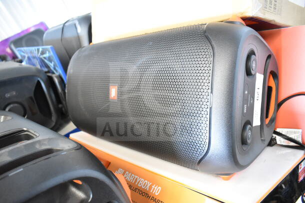JBL PartyBox 110 speaker on display shelf, featuring black grille, side controls, and branded logo. Appears in good condition.