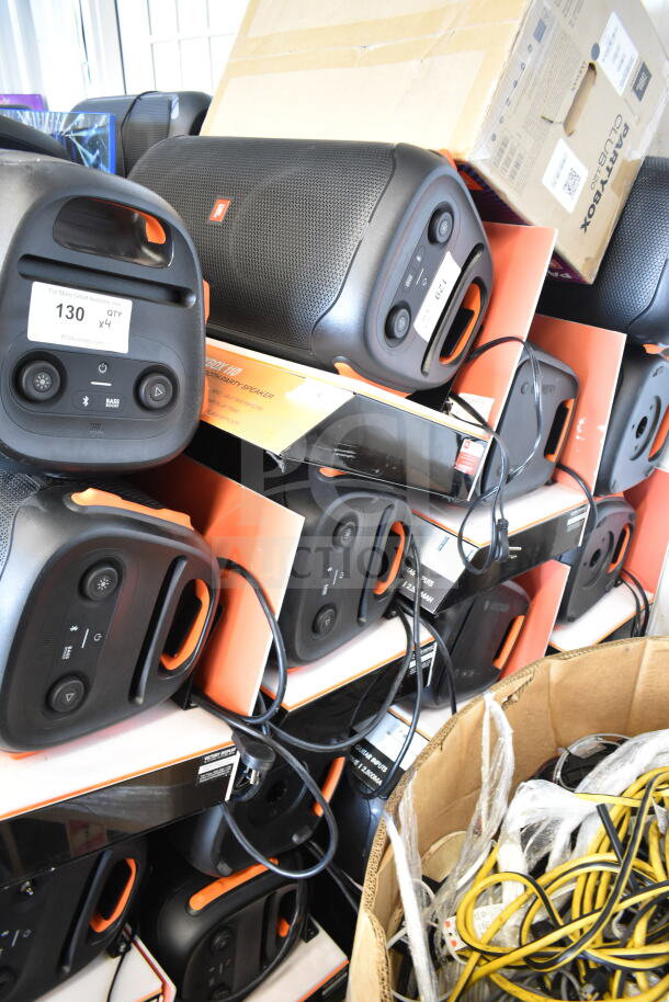 Stack of JBL PartyBox speakers in original packaging, labeled "130 QTY x4," indicating store display condition.