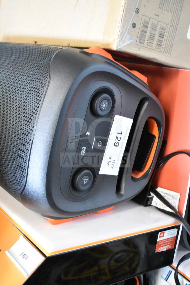 JBL speaker with interactive controls and carry handle, part of a store display set. Includes label indicating display unit.