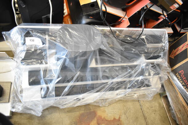 Surround soundbar system with speakers, wrapped in plastic. Tag reads "132". Display showing 5.1.2 channel setup. Great condition.