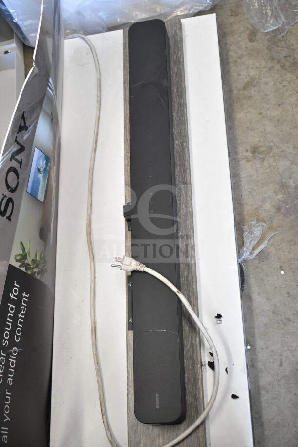 Sony soundbar and speaker store display, shown on a mounted board. Power cord attached. Used condition.
