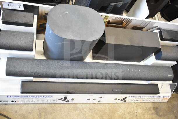 5.1.2 Surround Soundbar System store display with subwoofer and satellite speakers, featuring Dolby Atmos and DTS:X technology.