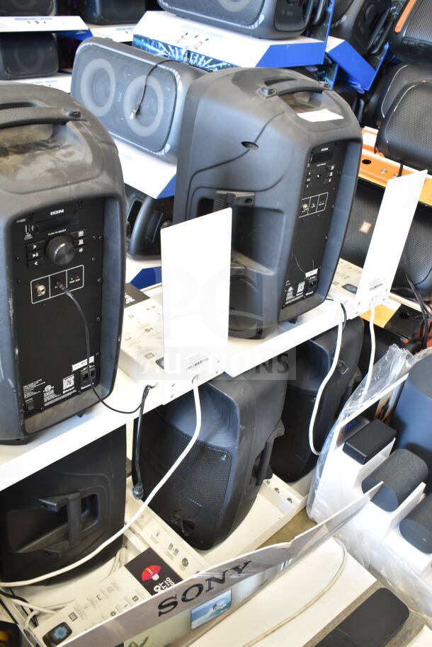 Store display of Pro Glow Ultra Speakers, featuring multiple black units, visible control panels, and brand labels.
