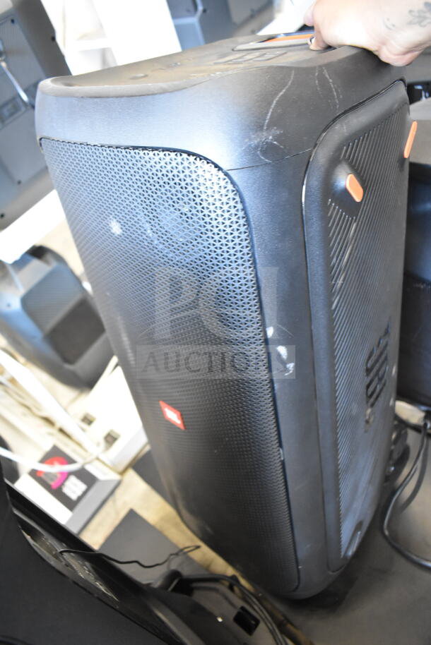 JBL Partybox 310 speaker, black with orange accents, visible wear, prominent JBL logo. Store display condition.