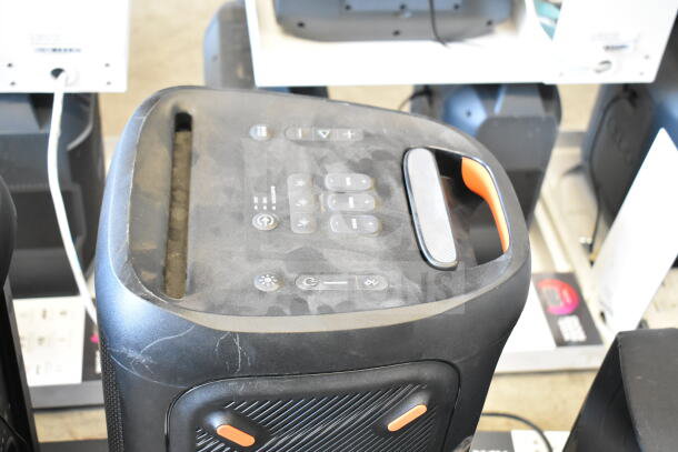 JBL Partybox 310 speaker display, featuring control panel and handle, visible dust, in-store setting.