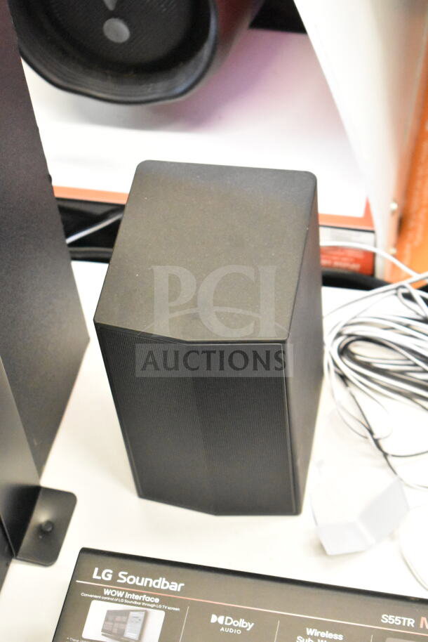 LG sound bar and 4 speakers in store display. Features Dolby Audio. Includes wires. Slight wear visible.