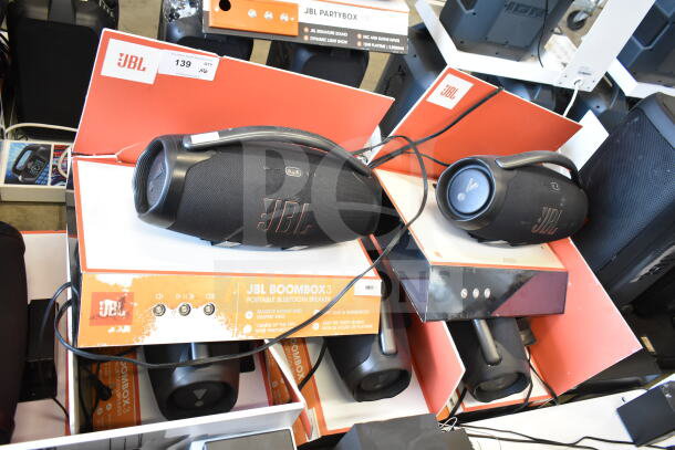 JBL Boombox 3 speakers on display, black and orange design, portable Bluetooth, tags showing item quantity and specs.