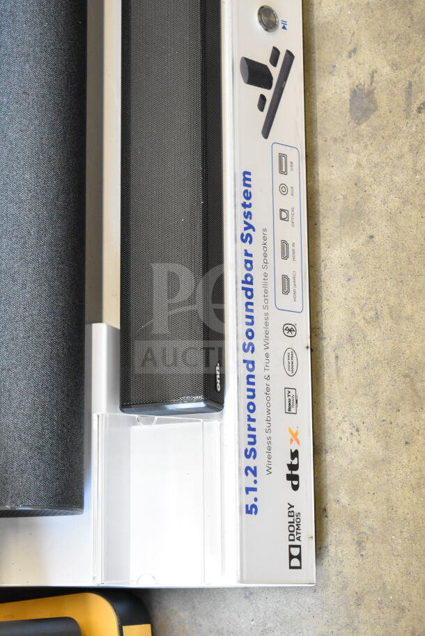Store display with two soundbars and speakers, featuring "5.1.2 Surround Soundbar System" label, Dolby Atmos, DTS:X logos.