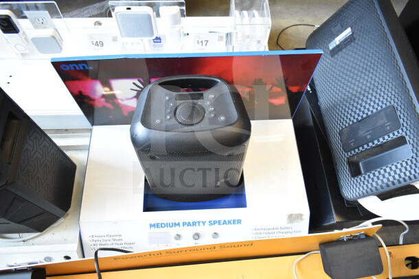 Display of three speakers including Ion, Onn Medium Party Speaker, Samsung. Features include 8-hour playtime, party sync mode.