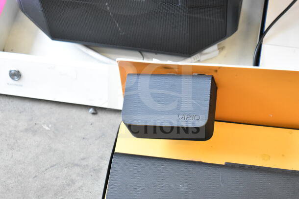 Store display featuring a Vizio sound bar and speaker. The speaker has a visible Vizio logo. Condition appears used.