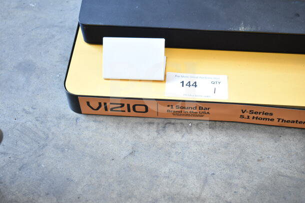 Vizio V-Series 5.1 sound bar and speaker display on stand. Label reads “#1 Sound Bar Brand in the USA.” Auction tag visible.