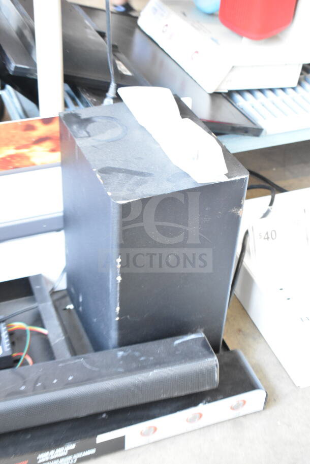 Store display featuring a JBL sound bar and speaker. Visible wear on the items, wiring seen. Ideal for tech displays.