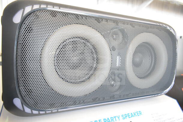 Onn large party speaker in store display, featuring dual woofers and metal grill. New condition. Bidding increases value fourfold.