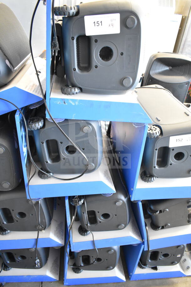 4 Onn large party speakers stacked in store display boxes. Each speaker includes cables. Labels show quantity 4 per display.