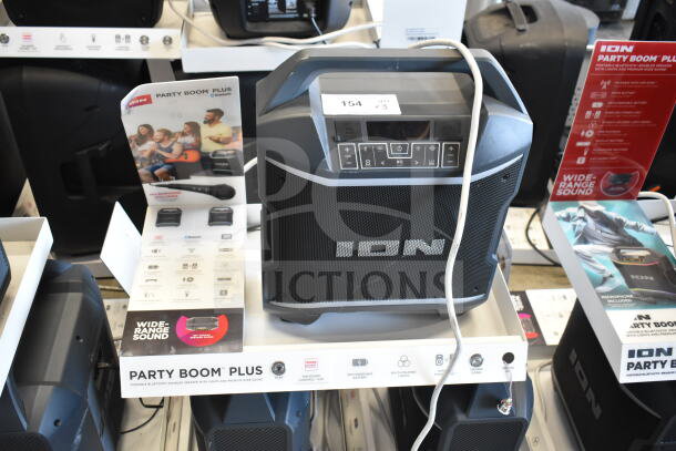 ION Party Boom Plus speaker with Bluetooth, LED lights, and wide-range sound on store display. Tags indicate features.