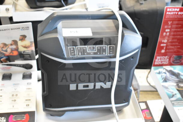 Ion Party Boom Plus speaker on display, featuring a control panel with buttons, in good condition. Includes product brochures.