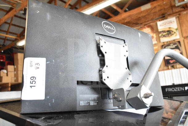 Three computer monitors; brands include Dell, elo, and LG. Monitor shown has Dell label. Visible mounting bracket, minor wear.